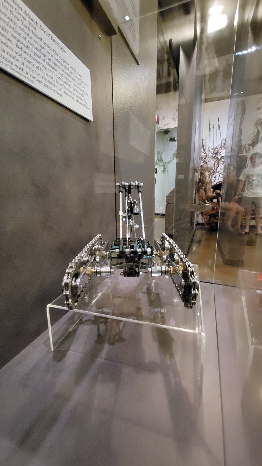 Figure 2 — The droid as an exemplar of the cybermechanical method: salvaged
bicycle chain and machined aluminum (industrial), brass thumb-nuts (traditional
hardware), and a glass medical syringe (t…
